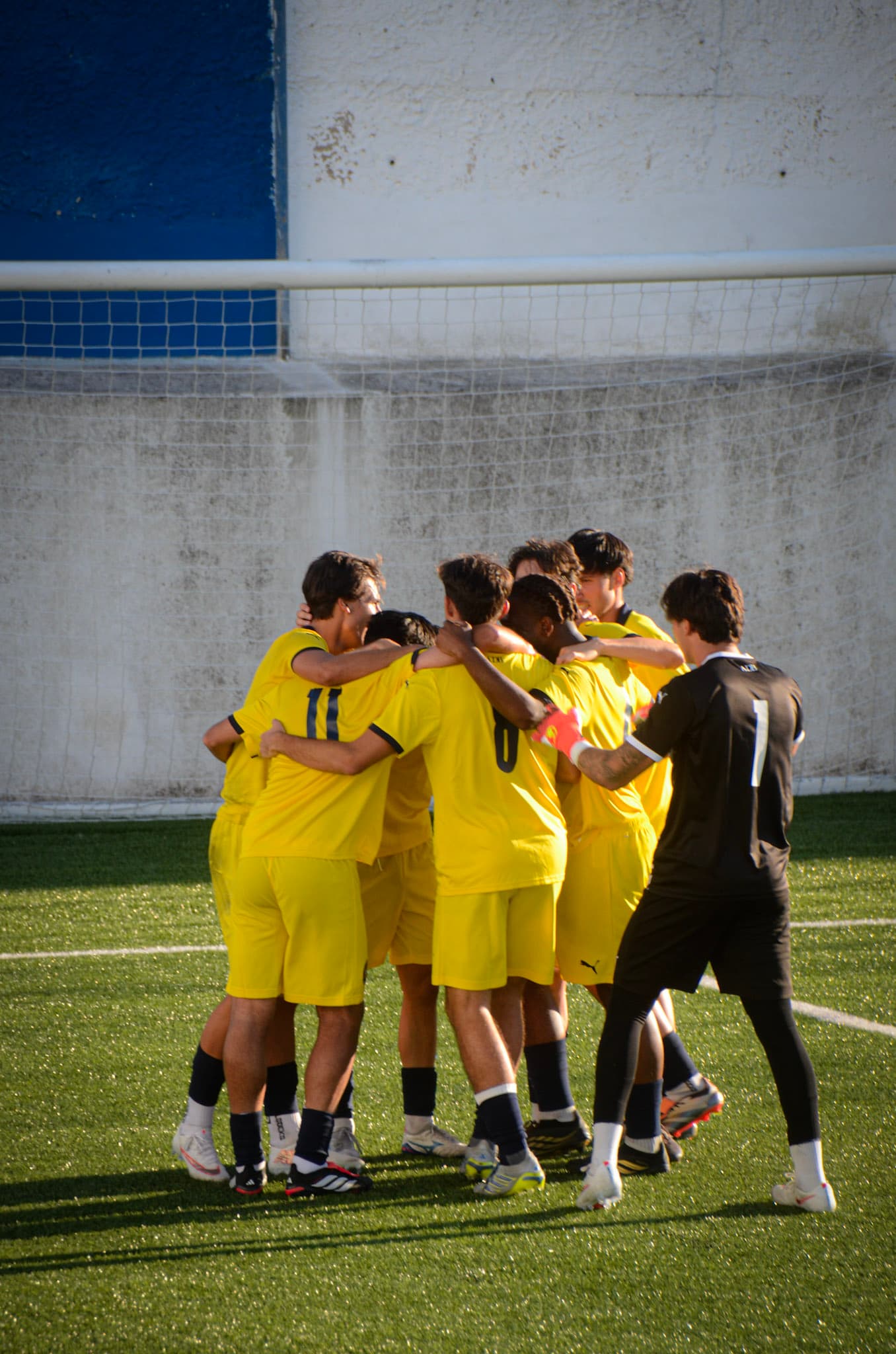 Bobadelense players embracing in celebration beside the goal
