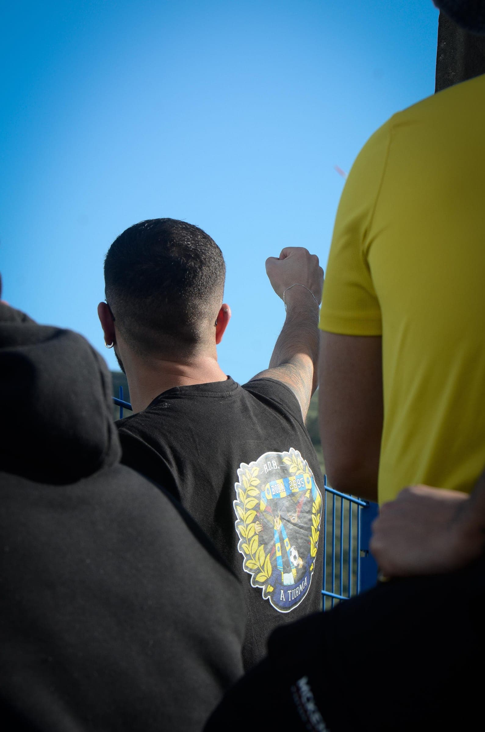 A supporter raising a fist to the sky in the stand